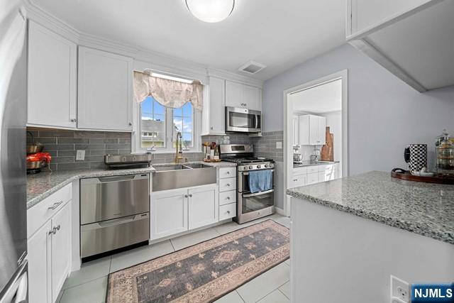 364 Rutland Avenue Teaneck, NJ 07666 - Photo 4 of 29 a kitchen with granite countertop a sink stainless steel appliances and cabinets