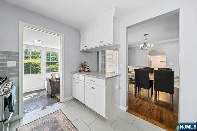 a kitchen with white cabinets and dining table