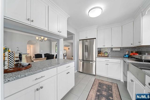 364 Rutland Avenue Teaneck, NJ 07666 - Photo 6 of 29 a kitchen with a sink dishwasher a refrigerator and white cabinets