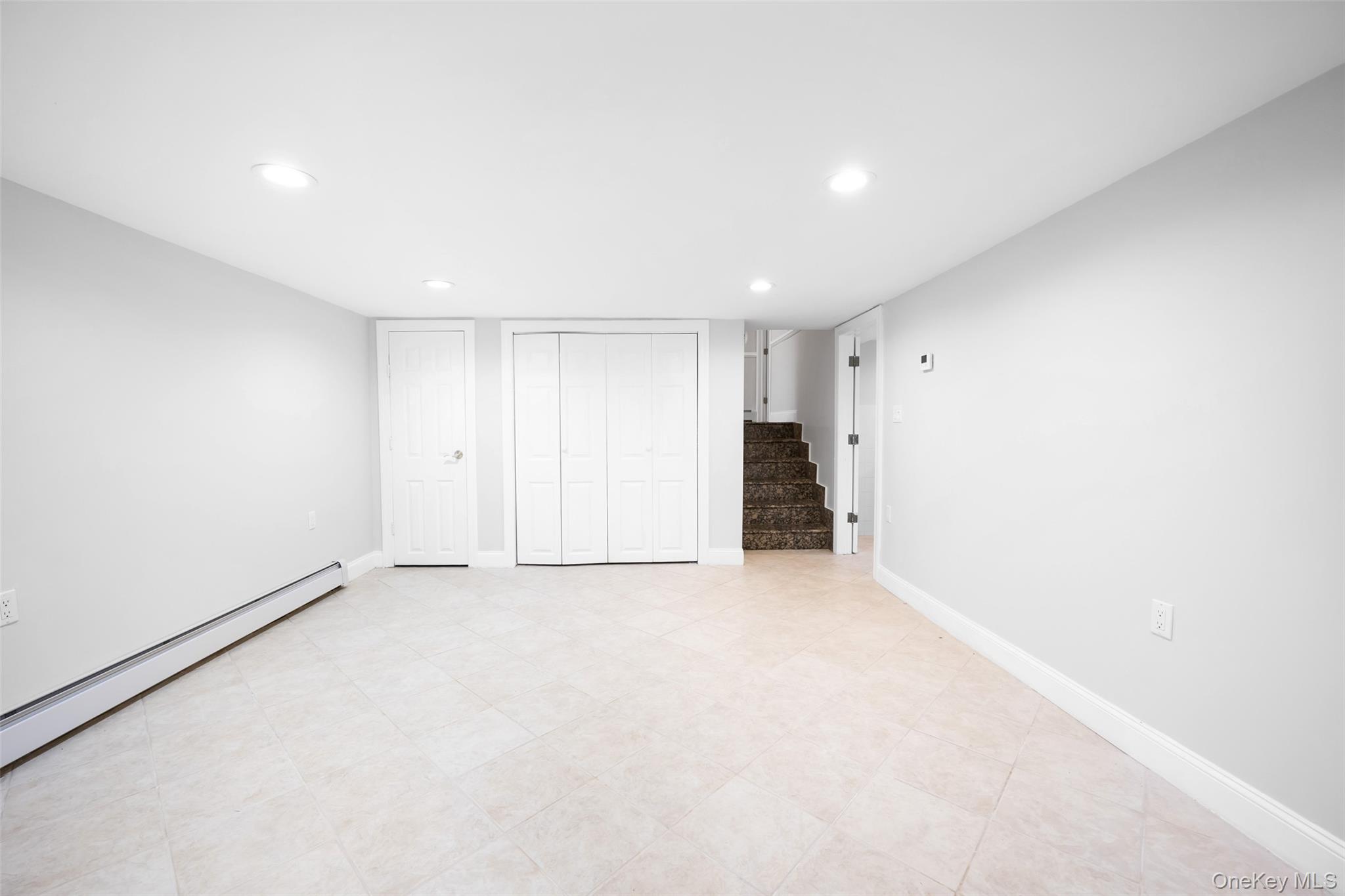 36 Red Spring Lane Glen Cove, NY 11542 - Photo 24 of 33 Bonus room (lower level) – Versatile open space ideal for a home office, playroom, or extra lounge, with soft neutral tones and recessed lighting.