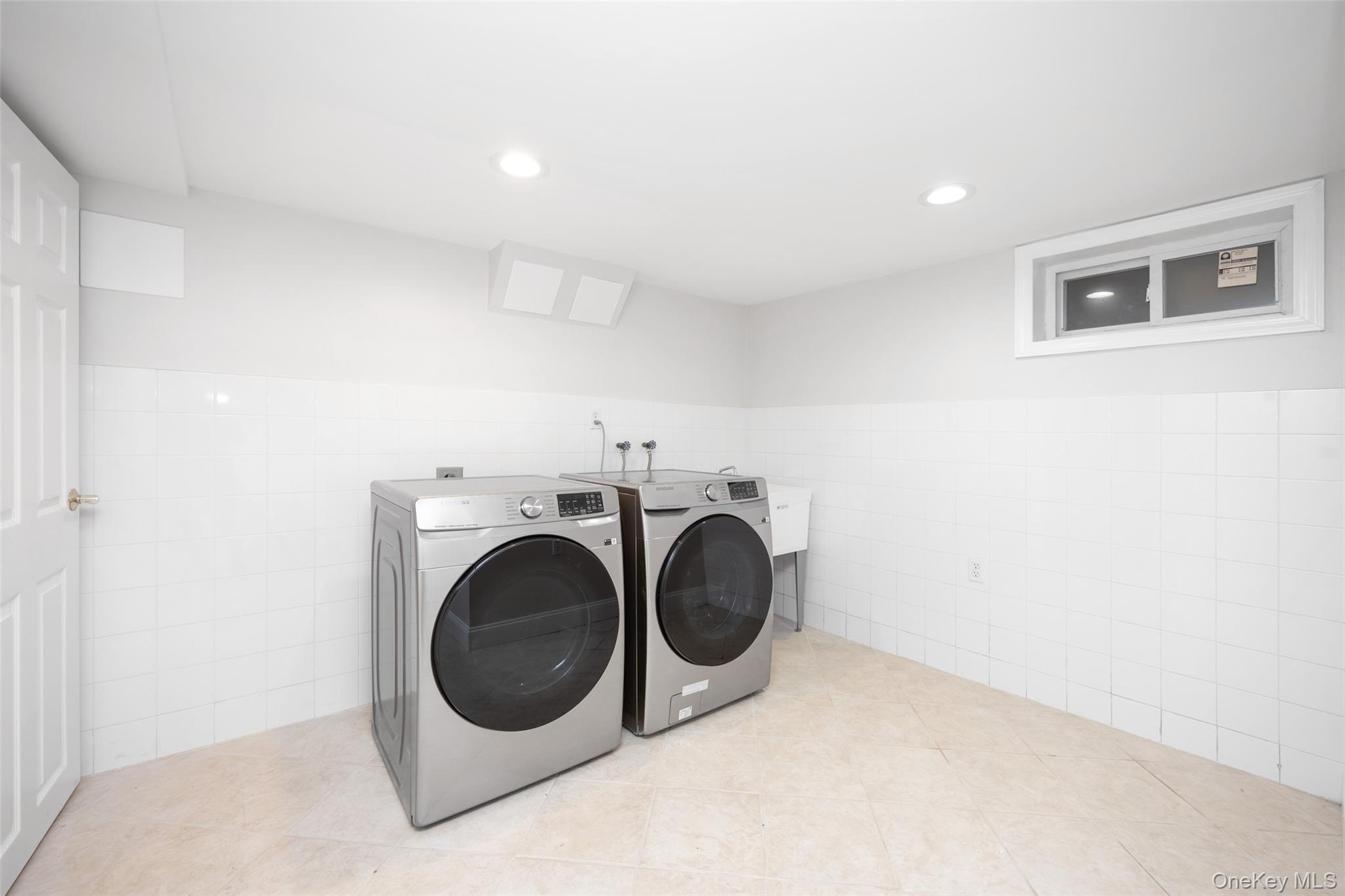 36 Red Spring Lane Glen Cove, NY 11542 - Photo 25 of 33 Laundry room featuring tile walls, wainscoting, independent washer and dryer, recessed lighting, and tile patterned floors