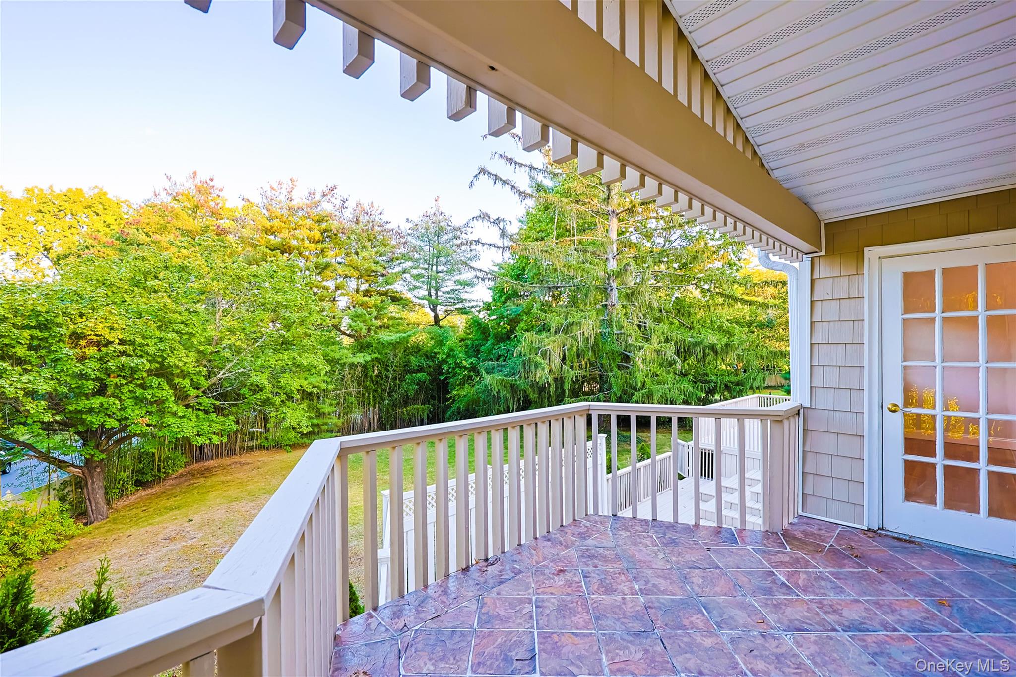 36 Red Spring Lane Glen Cove, NY 11542 - Photo 27 of 33 Lower-level walkout – Glass sliders provide direct access from the lower living area to the private outdoor patio.