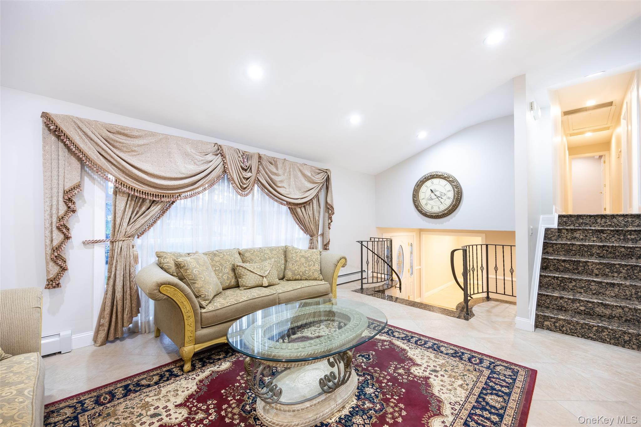 36 Red Spring Lane Glen Cove, NY 11542 - Photo 3 of 33 Open Living and Dining Space – Expansive area combining kitchen, dining, and living spaces under vaulted ceilings, creating an inviting central hub for daily living.