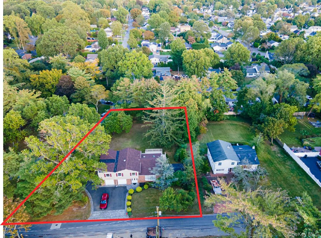 36 Red Spring Lane Glen Cove, NY 11542 - Photo 33 of 33 Aerial property view – Wide aerial perspective showcasing the home’s large lot (outlined in red), framed by mature trees and quiet residential streets.