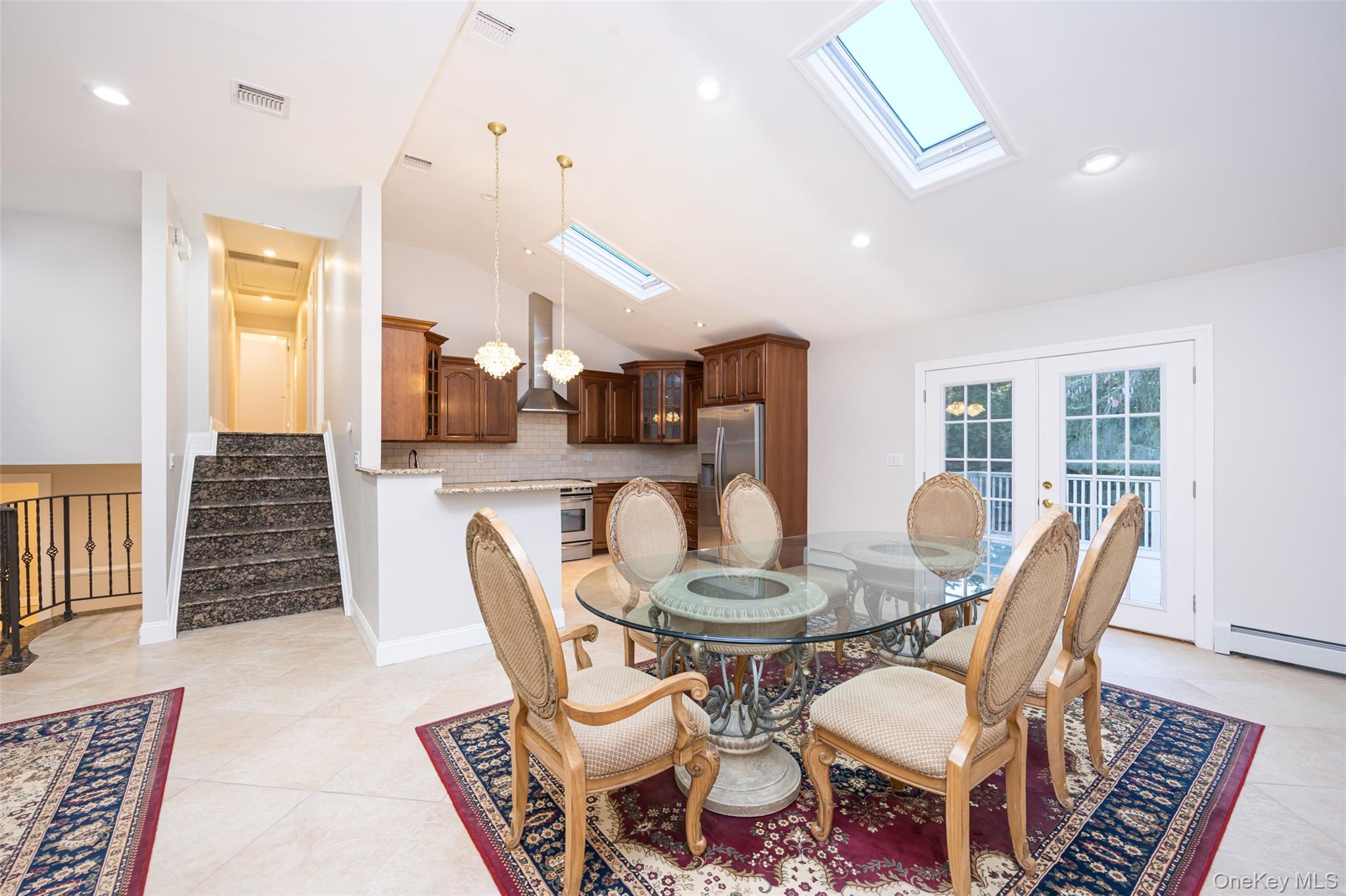 36 Red Spring Lane Glen Cove, NY 11542 - Photo 4 of 33 Dining area (alternate view) – Showcasing the seamless flow between dining, kitchen, and stairway, perfect for open-concept living.