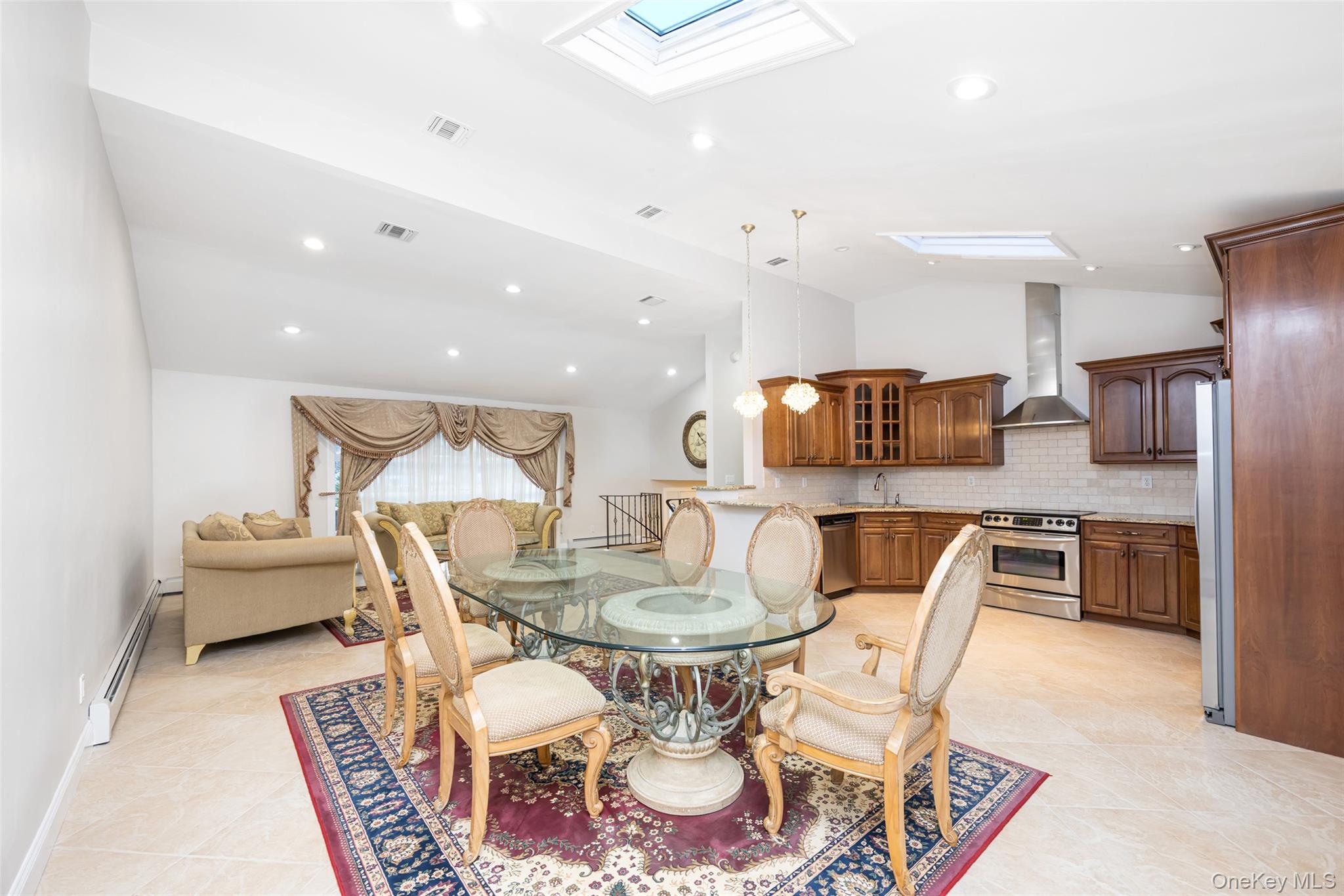 36 Red Spring Lane Glen Cove, NY 11542 - Photo 5 of 33 Family Room – Spacious and freshly painted, this versatile room offers recessed skylight lighting, neutral tile flooring, and sliding doors opening to the backyard patio—ideal for gatherings or recreation.