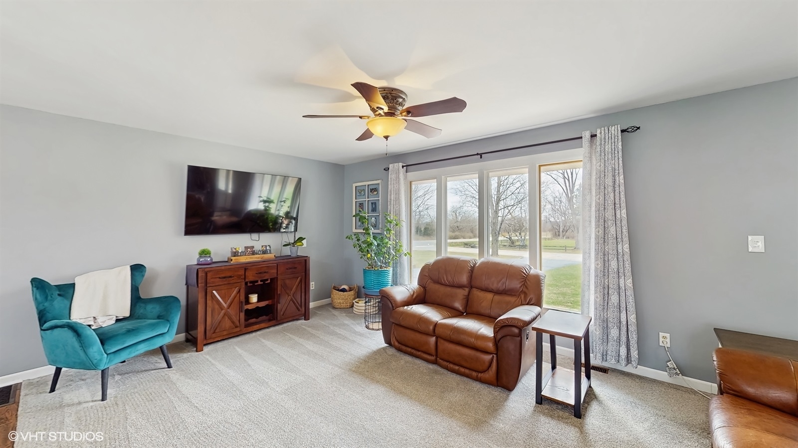 2606 Martin Drive Spring Grove, IL 60081 - Photo 2 of 32 a living room with furniture a flat screen tv and a floor to ceiling window