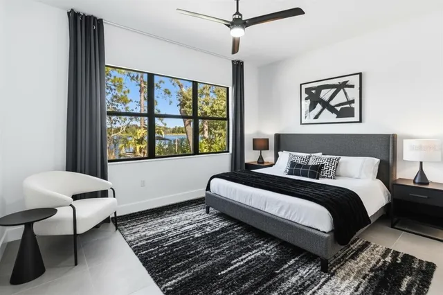 a bedroom with a bed lamp and a window