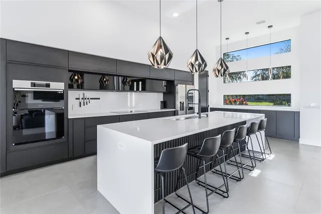 a kitchen with stainless steel appliances kitchen island a table chairs in it and wooden floors