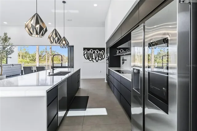 a kitchen with stainless steel appliances granite countertop a sink and a refrigerator