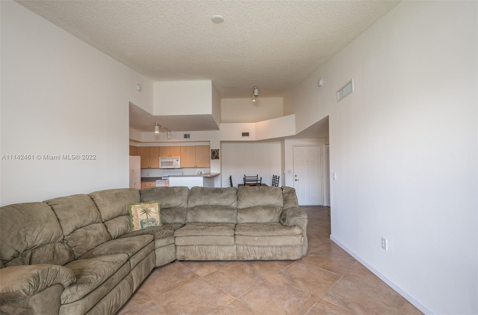 8030 North Nob Hill Road, Unit 306 Tamarac, FL 33321 - Photo 12 of 26 a living room with furniture and a chandelier