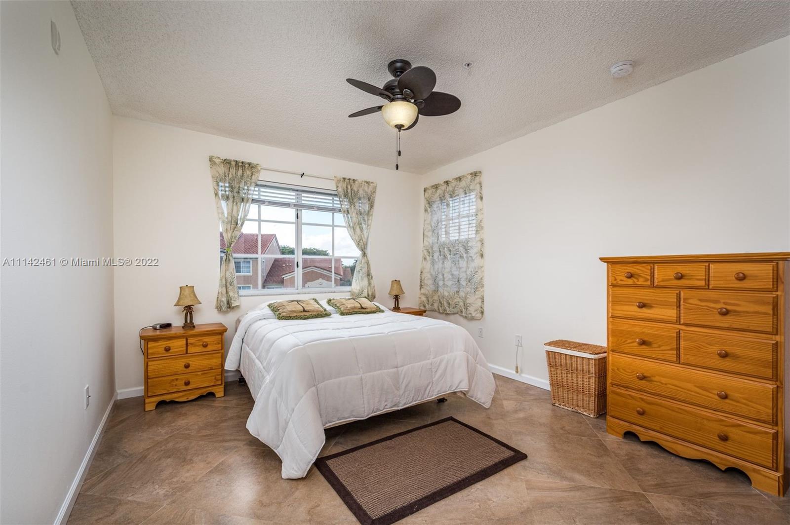 8030 North Nob Hill Road, Unit 306 Tamarac, FL 33321 - Photo 13 of 26 a bedroom with a bed and a dresser