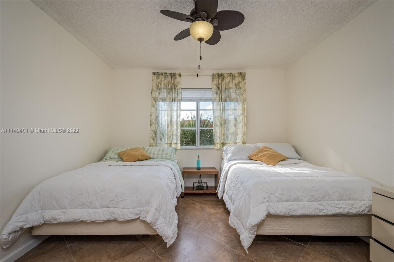 8030 North Nob Hill Road, Unit 306 Tamarac, FL 33321 - Photo 16 of 26 a bedroom with two beds and a chandelier