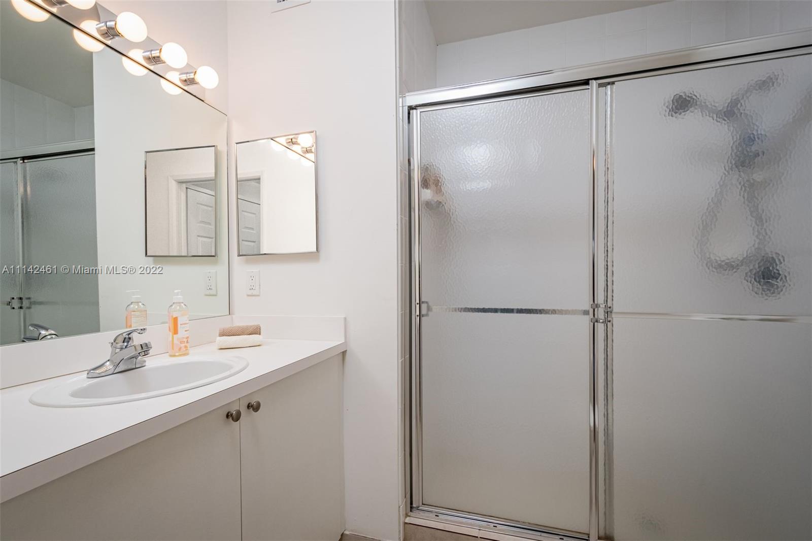 8030 North Nob Hill Road, Unit 306 Tamarac, FL 33321 - Photo 17 of 26 a bathroom with a shower sink and mirror
