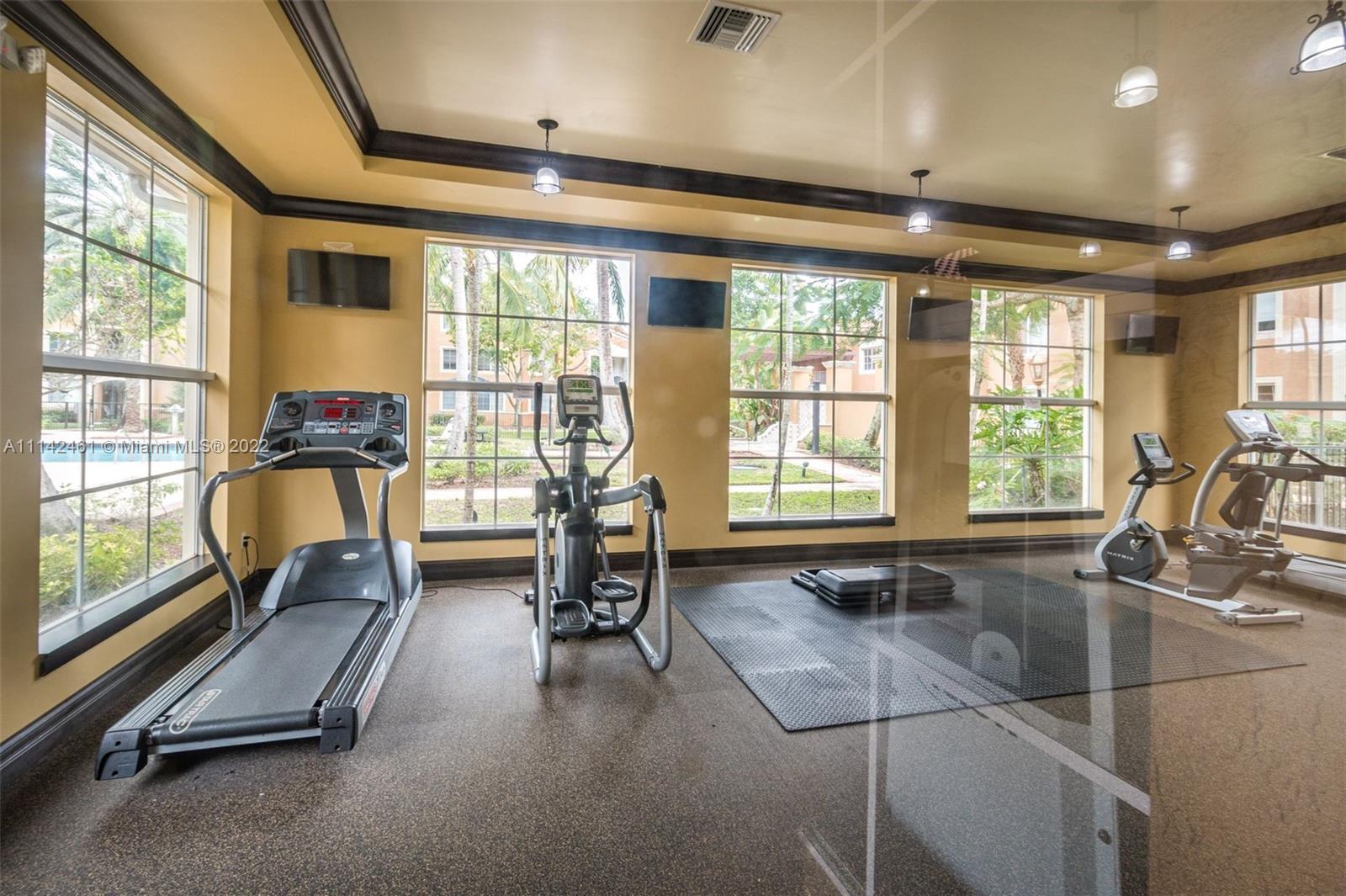 8030 North Nob Hill Road, Unit 306 Tamarac, FL 33321 - Photo 23 of 26 a room with gym equipment and large windows