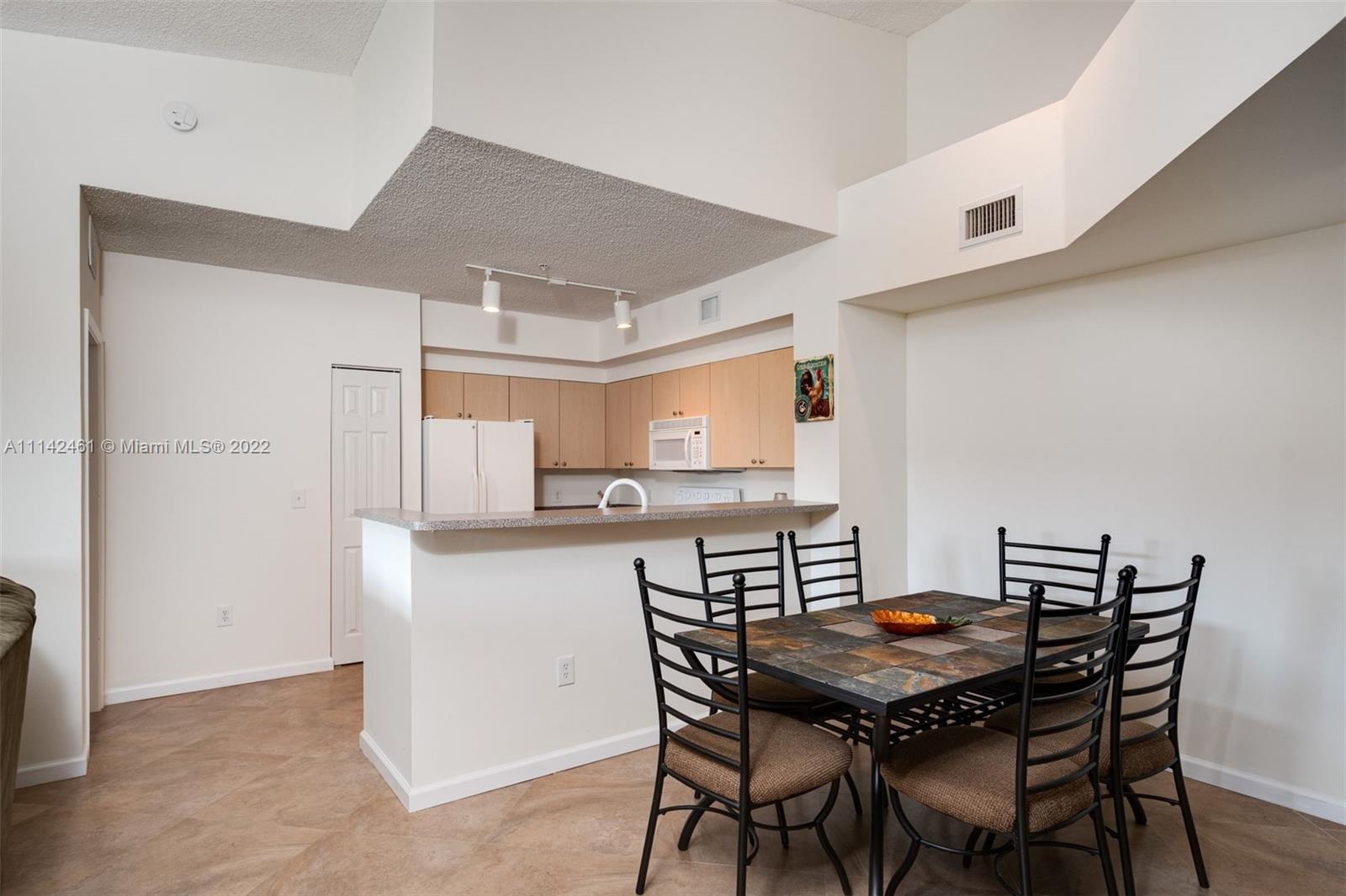 8030 North Nob Hill Road, Unit 306 Tamarac, FL 33321 - Photo 9 of 26 a kitchen with a table and chairs in it