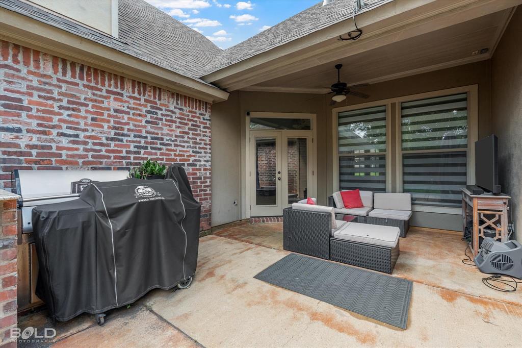 2220 Forest Hills Boulevard Haughton, LA 71037 - Photo 5 of 40 Covered patio featuring a brick exterior wall, concrete flooring, and an exterior ceiling fan
