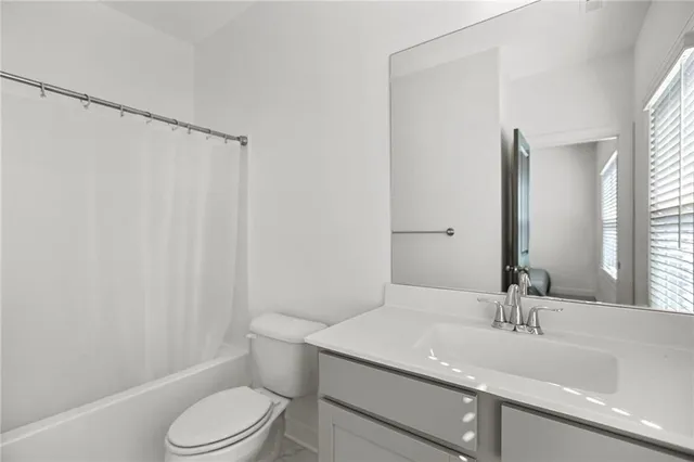 a bathroom with a sink a toilet a mirror and shower