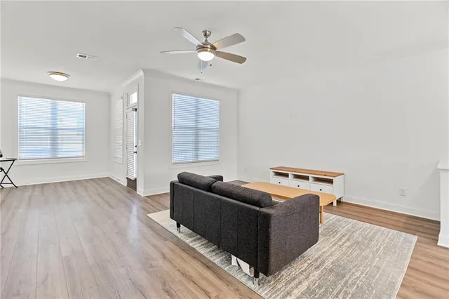 a living room with furniture and a wooden floor