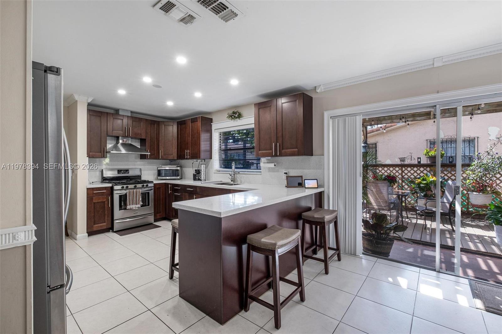 2862 Southwest 38th Court Miami, FL 33134 - Photo 33 of 67 a kitchen with kitchen island granite countertop stainless steel appliances a sink a counter top cabinets appliances and a window