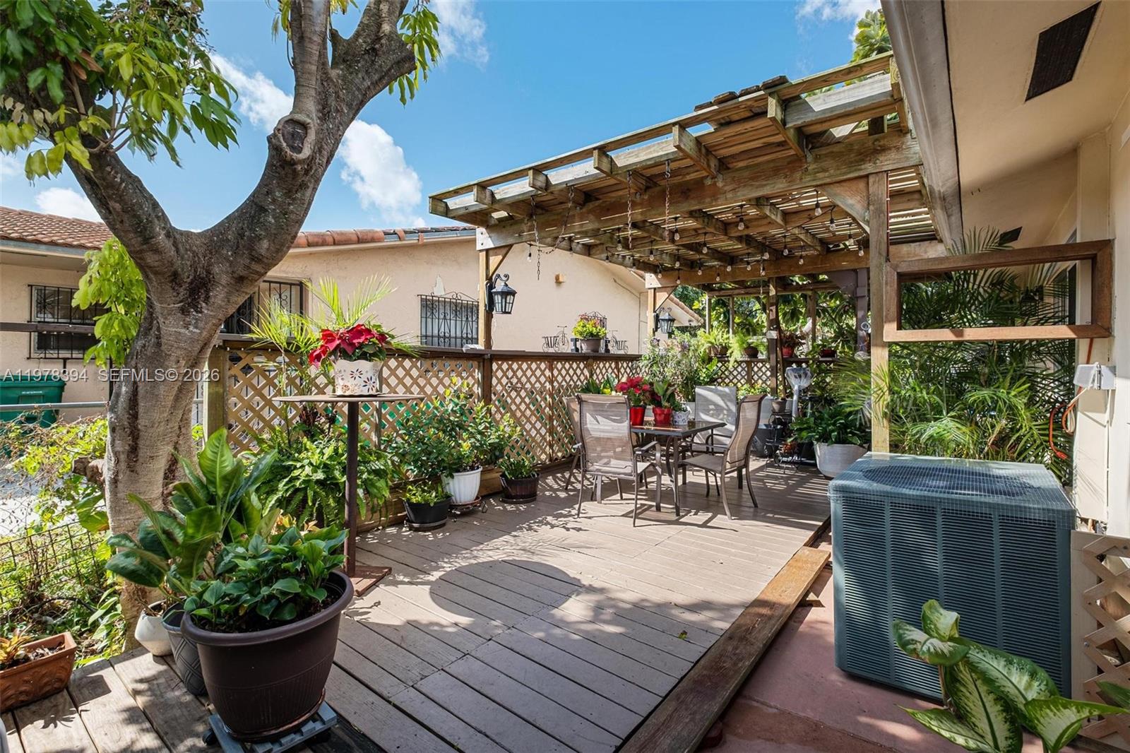 2862 Southwest 38th Court Miami, FL 33134 - Photo 50 of 67 a view of a patio with table and chairs potted plants and large tree