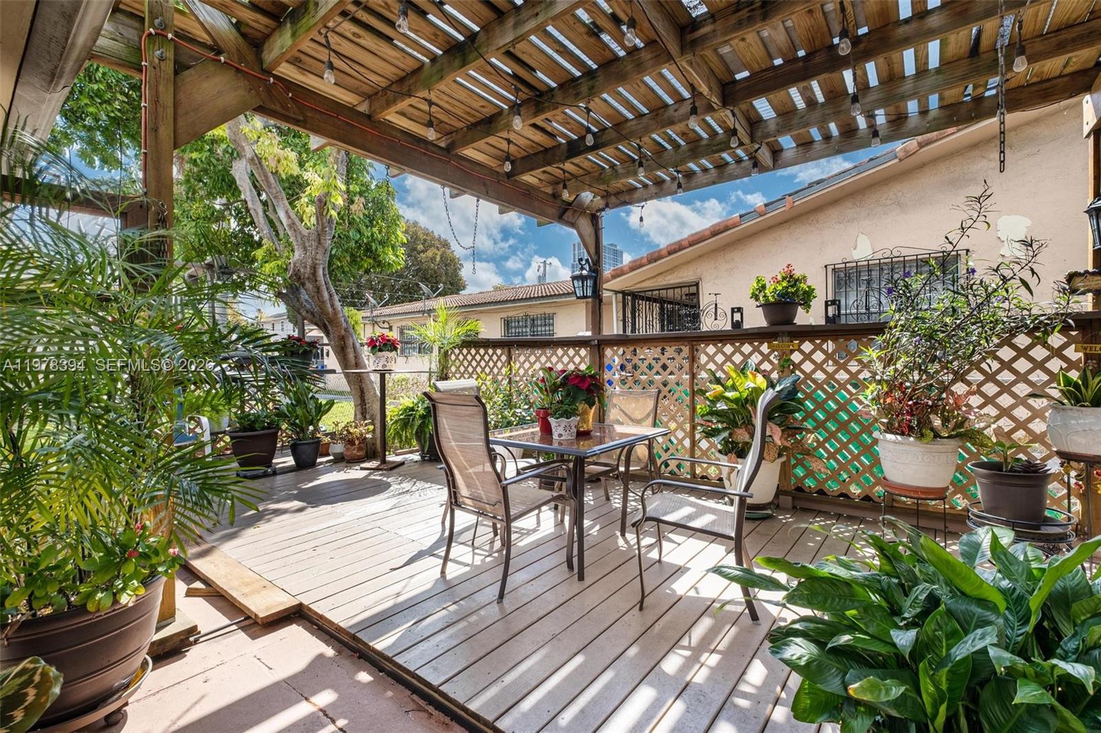 2862 Southwest 38th Court Miami, FL 33134 - Photo 52 of 67 a view of a patio with table and chairs potted plants and floor to ceiling window