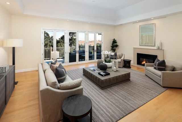 a living room with furniture a fireplace and a large window