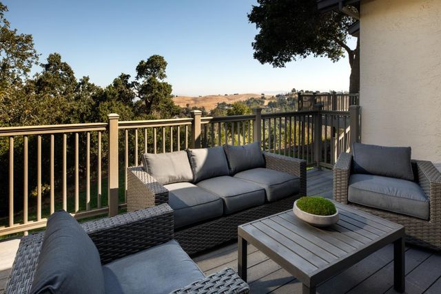 a balcony with wooden floor and outdoor seating