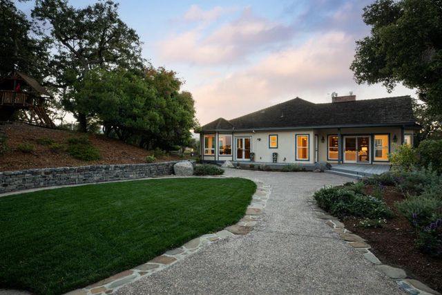 a view of a yard and front a house with a garden