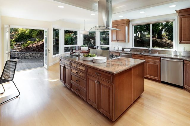 a kitchen with stainless steel appliances granite countertop a stove a sink and a oven