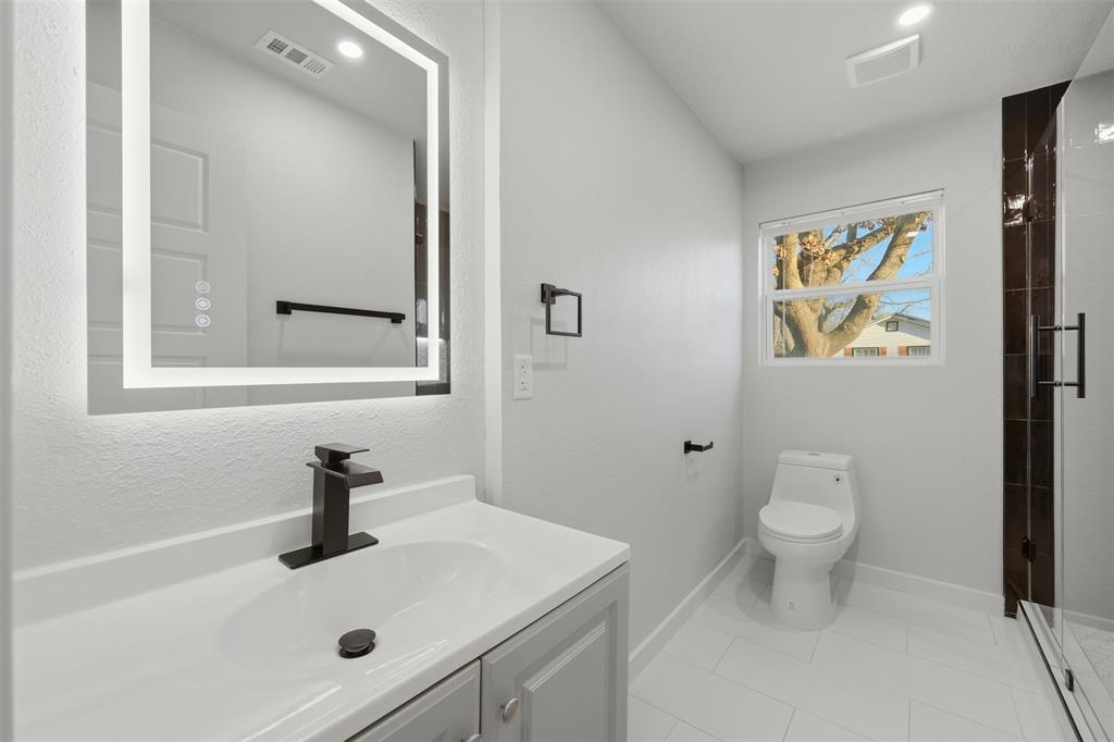 502 Madison Street Cleburne, TX 76033 - Photo 20 of 30 a bathroom with a sink a toilet and a mirror