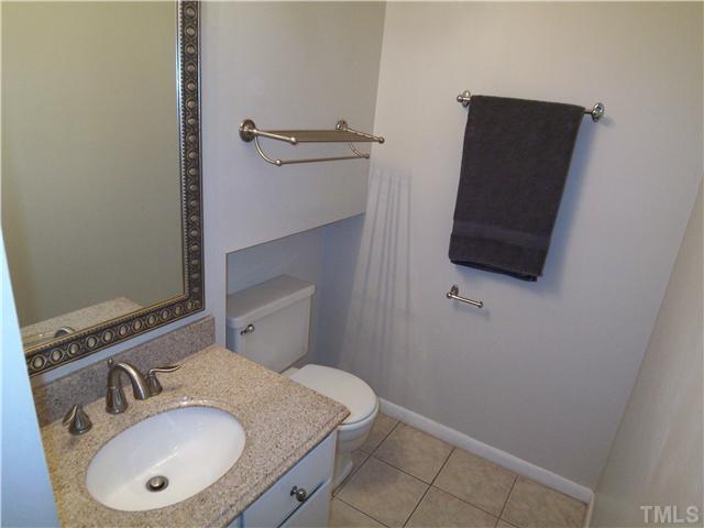 7300 Sandy Creek Drive Raleigh, NC 27615 - Photo 13 of 25 a bathroom with a sink toilet and mirror