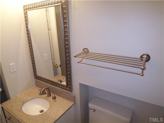 7300 Sandy Creek Drive Raleigh, NC 27615 - Photo 14 of 25 a bathroom with a sink and a mirror