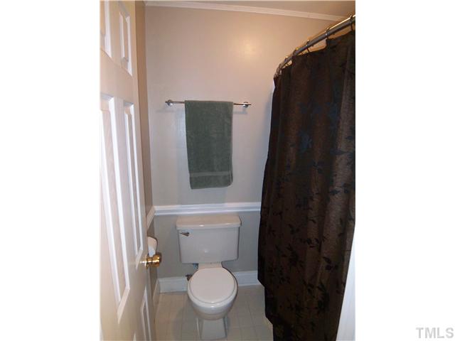 7300 Sandy Creek Drive Raleigh, NC 27615 - Photo 17 of 25 a bathroom with a toilet and a vanity
