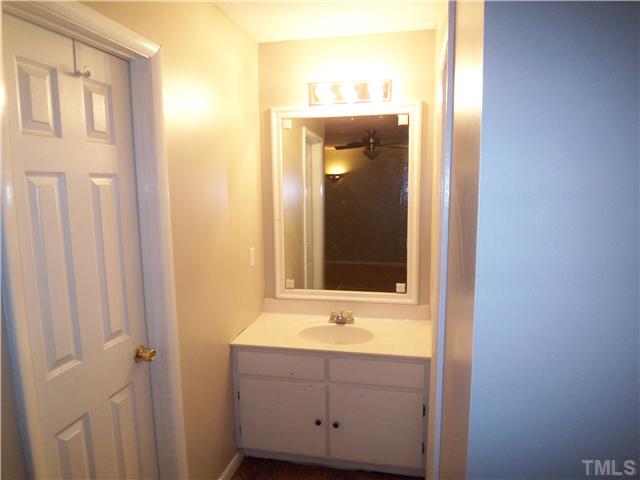 7300 Sandy Creek Drive Raleigh, NC 27615 - Photo 18 of 25 a bathroom with a sink and a mirror