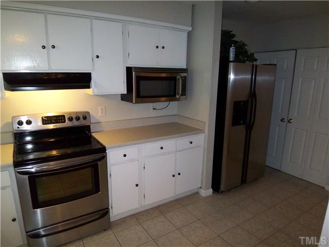 7300 Sandy Creek Drive Raleigh, NC 27615 - Photo 5 of 25 a kitchen with a stove and a microwave