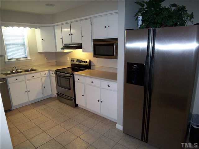 7300 Sandy Creek Drive Raleigh, NC 27615 - Photo 6 of 25 a kitchen with granite countertop white cabinets and stainless steel appliances