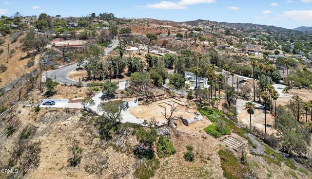 an aerial view of house with yard and mountain view in back