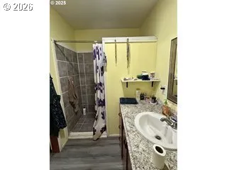 a bathroom with a granite countertop shower a mirror and a sink
