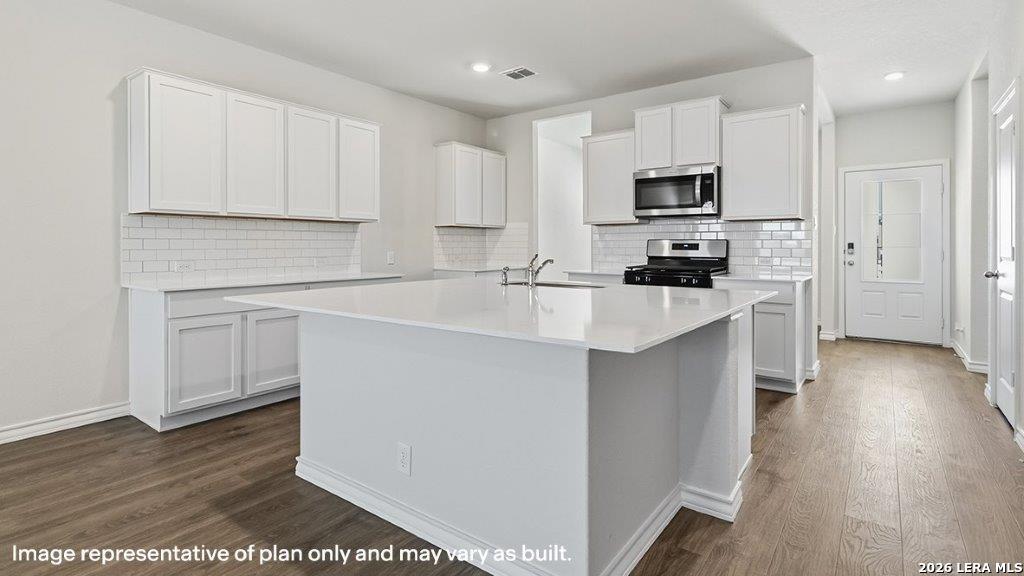 523 Avalon Banks Cibolo, TX 78108 - Photo 7 of 79 a kitchen with white cabinets and stainless steel appliances