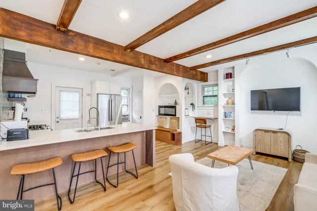 a living room with furniture a flat screen tv and kitchen view