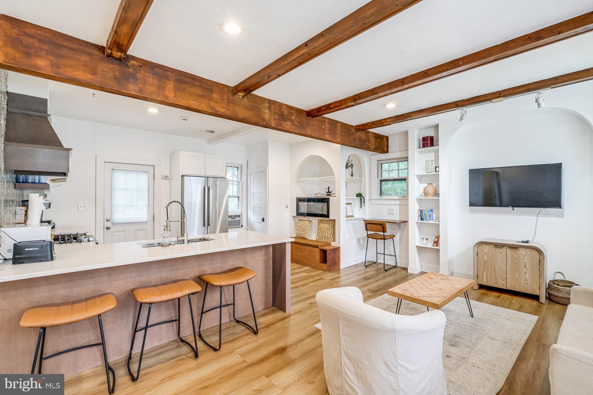 4209 Queensbury Road Hyattsville, MD 20781 - Photo 2 of 12 a living room with furniture a flat screen tv and kitchen view