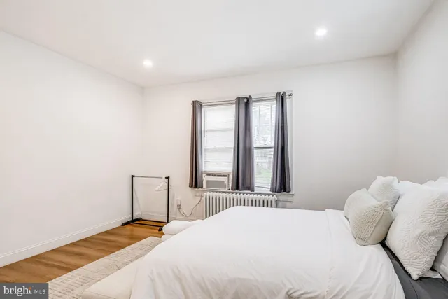 a bedroom with a bed and a large window