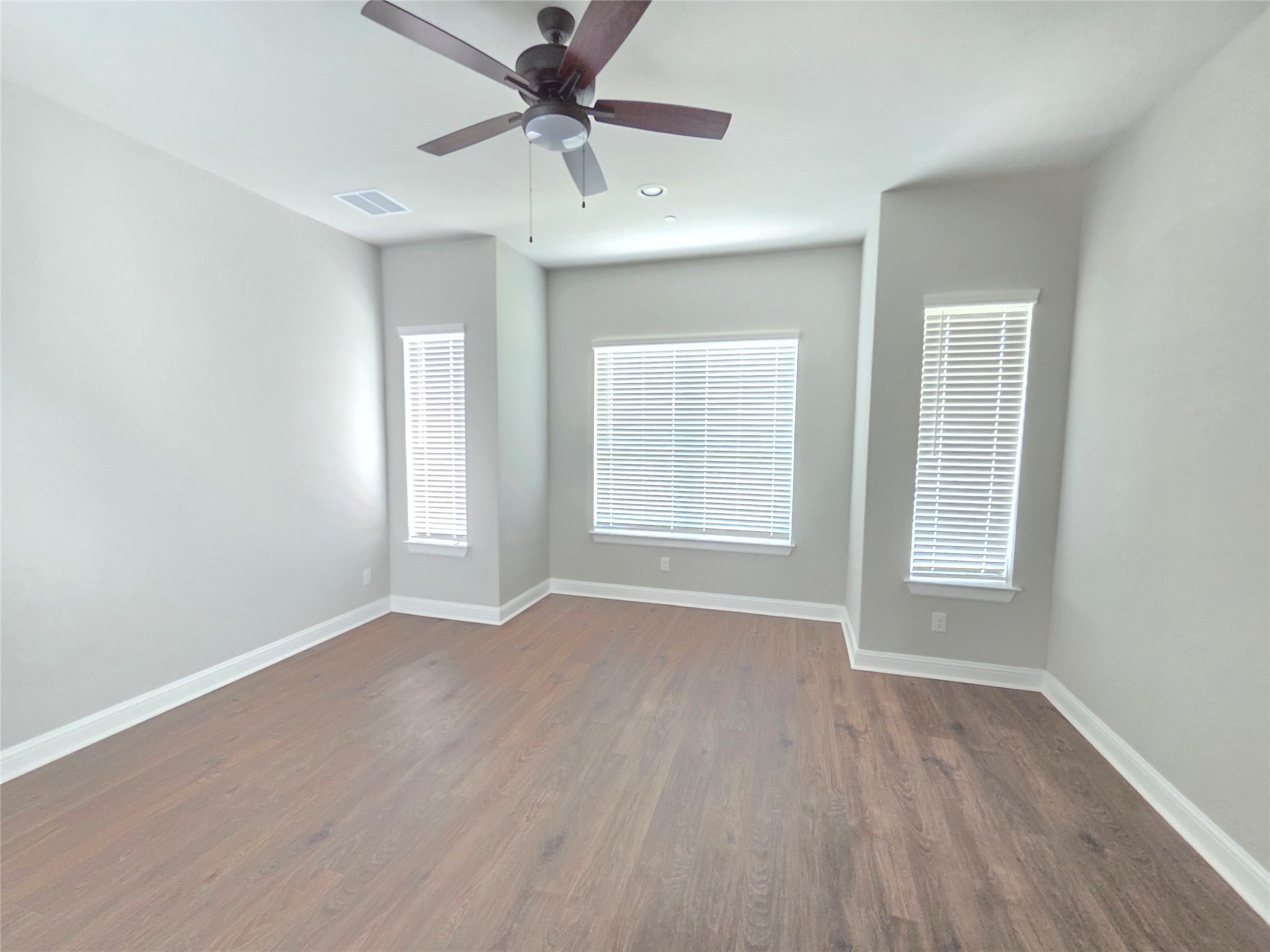 600 C-Bar Ranch Trail, Unit 121 Cedar Park, TX 78613 - Photo 16 of 32 Well-lit living area with rich wood flooring and a contemporary ceiling fan for comfort.