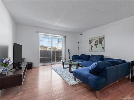 a living room with furniture and a flat screen tv with wooden floor