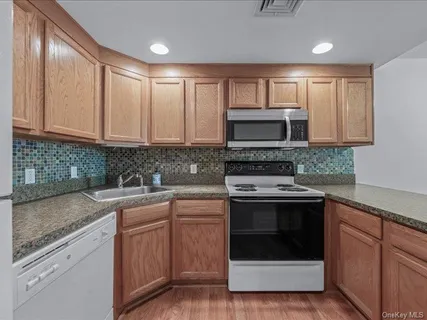 a kitchen with sink a microwave and cabinets