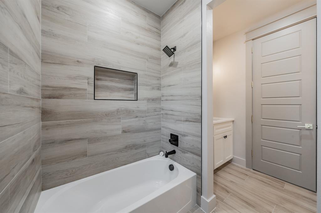 7805 Kenleigh Lane Rio Vista, TX 76093 - Photo 24 of 40 Bathroom with vanity, washtub / shower combination, and wood finish floors