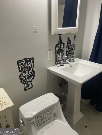 a bathroom with a sink a toilet and mirror