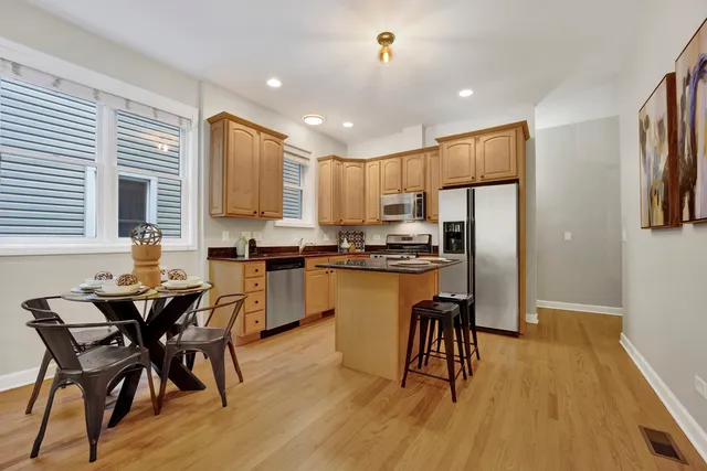 a kitchen with a table chairs refrigerator microwave and cabinets