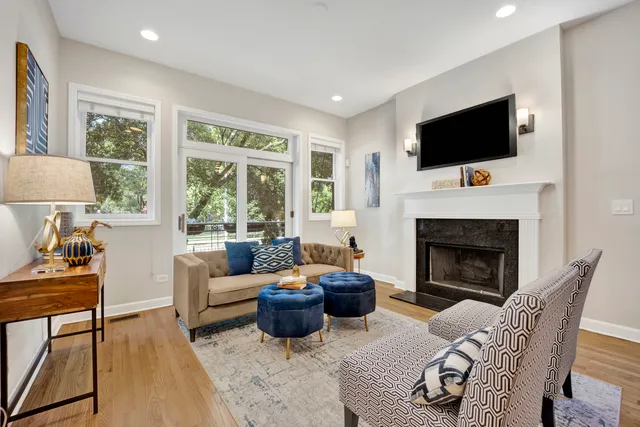 a living room with furniture a flat screen tv and a fireplace